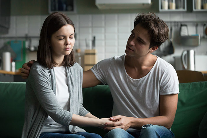 Young man consoles girlfriend in a kitchen setting, reflecting on depressed and lazy behaviors after snapping at her. Young man consoles girlfriend in a kitchen setting, reflecting on depressed and lazy behaviors after snapping at her.