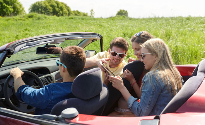 Four young adults in a convertible car on a trip, highlighting relationship tension over a trip with a female friend. Four young adults in a convertible car on a trip, highlighting relationship tension over a trip with a female friend.
