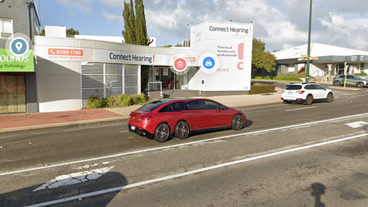 Red car with six wheels on a city street captured by Google Earth and Maps showing something unexpected on the road.