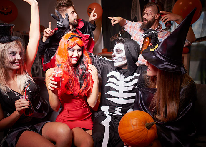 Group of friends in Halloween costumes including skeleton and witch, highlighting masculinity so fragile theme in social setting. Group of friends in Halloween costumes including skeleton and witch, highlighting masculinity so fragile theme in social setting.