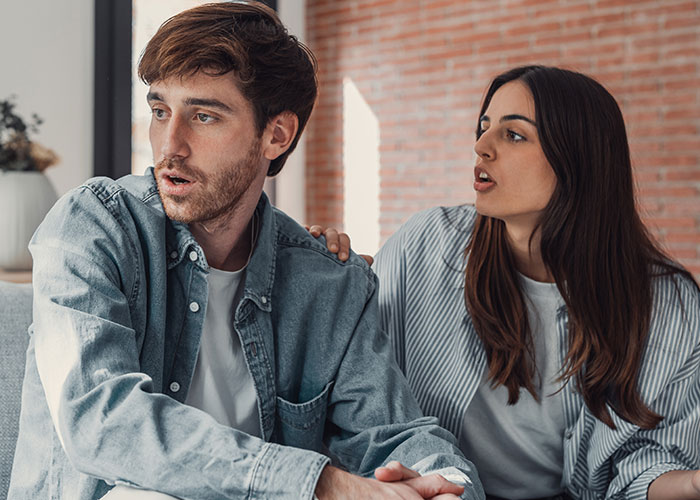Young man looks uncomfortable while girlfriend talks to him, illustrating masculinity so fragile impacting their relationship. Young man looks uncomfortable while girlfriend talks to him, illustrating masculinity so fragile impacting their relationship.