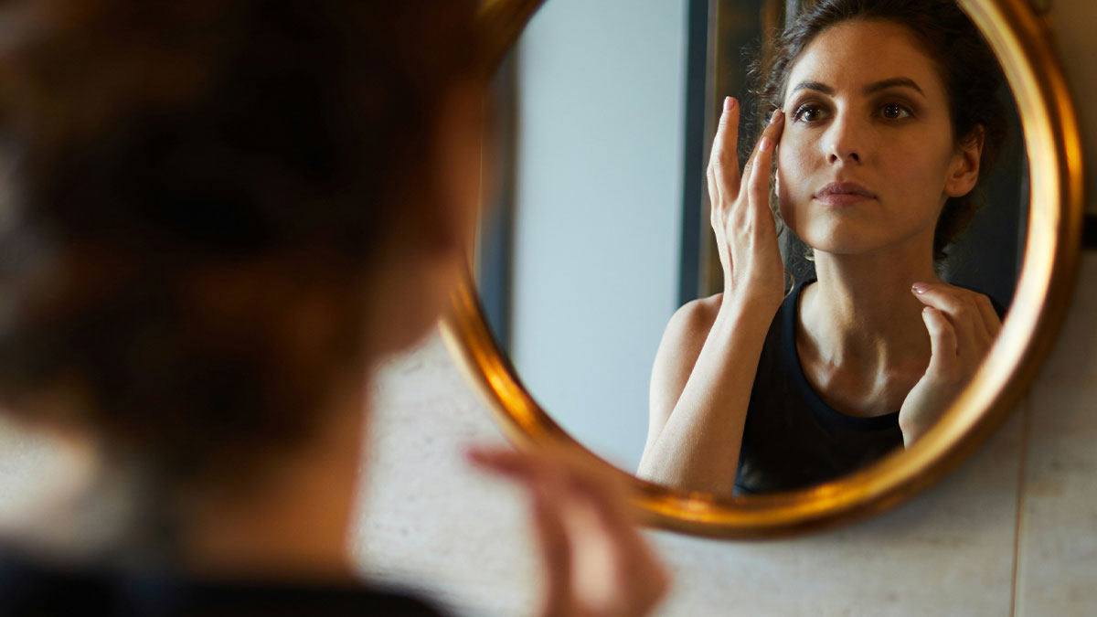 Woman reflecting in a round mirror, contemplating the hardest truths about their lives women had to accept.