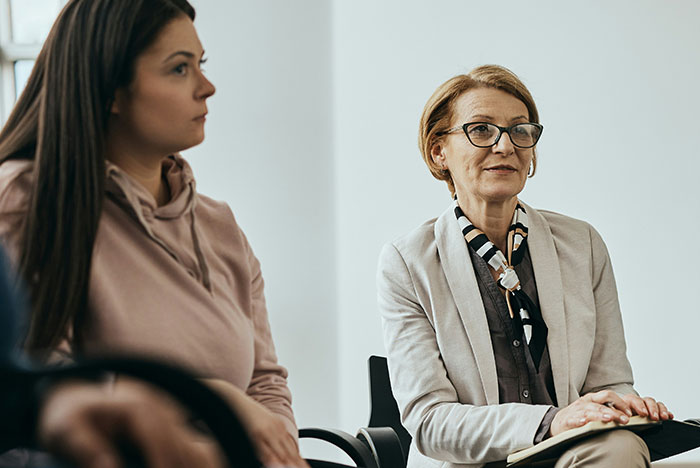 Two women participating in a serious discussion, reflecting on hard truths women often realize in life.