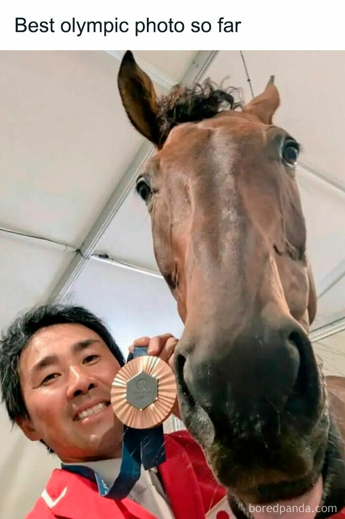 Man in red jacket holding an Olympic bronze medal taking a close-up selfie with a horse, a relatable meme moment.