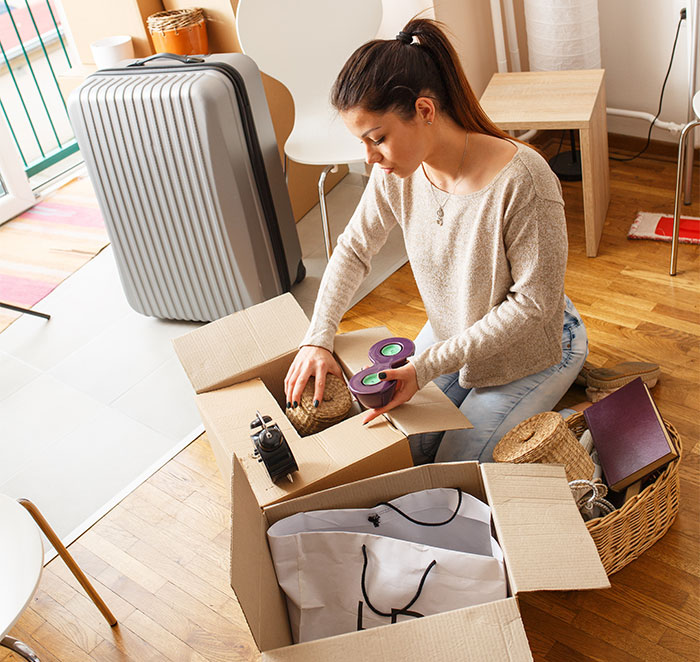 Woman packing tea set into a box near luggage, symbolizing conflict involving a stolen tea set and ruined marriage. Woman packing tea set into a box near luggage, symbolizing conflict involving a stolen tea set and ruined marriage.