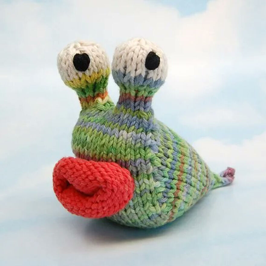 Colorful crochet animal resembling a snail with expressive eyes and red lips, showcasing crochet animals with personality.