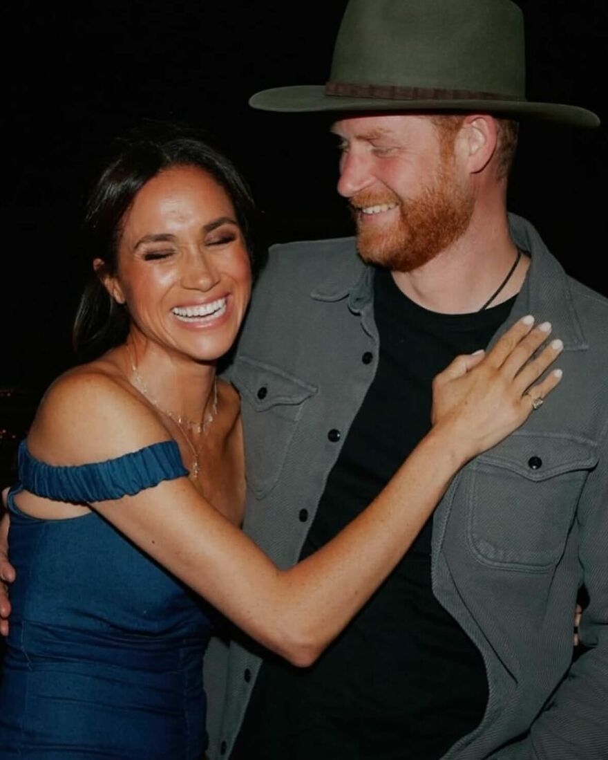 Prince Harry And Meghan Markle embracing and smiling warmly in a candid moment demonstrating enduring love and connection.