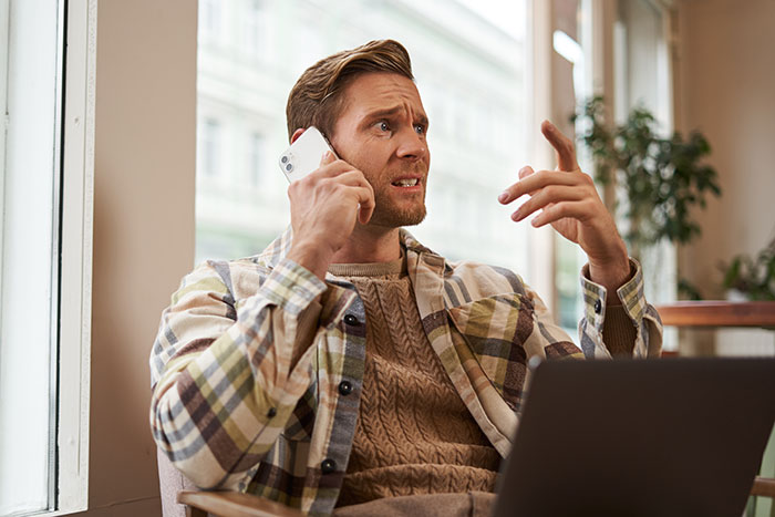 Young man talking on phone looking stressed and confused, illustrating bestie dating after rejection scenario. Young man talking on phone looking stressed and confused, illustrating bestie dating after rejection scenario.