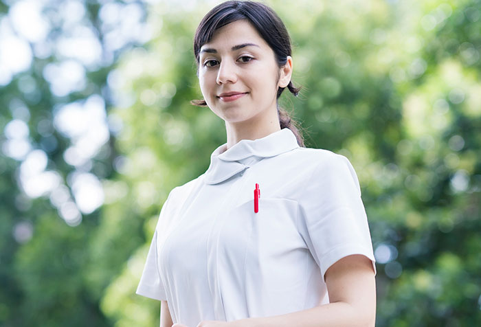 Young woman in white medical uniform outdoors, representing cases of people self-diagnosing correctly despite initial doubt.
