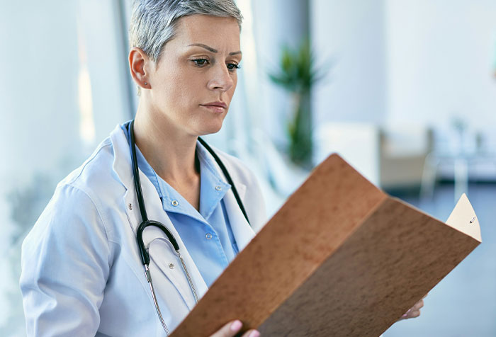 Female doctor with stethoscope reviewing a medical file, illustrating cases of people self-diagnosing correctly.