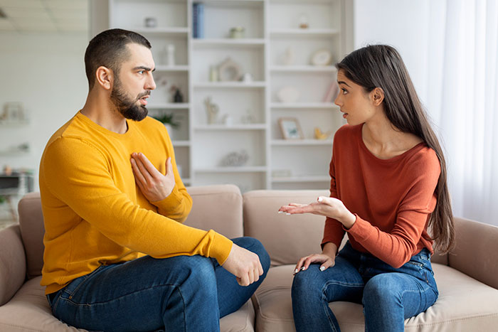 Couple having a serious discussion on couch, wife upset and taking off wedding ring after family sides with creepy brother-in-law. Couple having a serious discussion on couch, wife upset and taking off wedding ring after family sides with creepy brother-in-law.