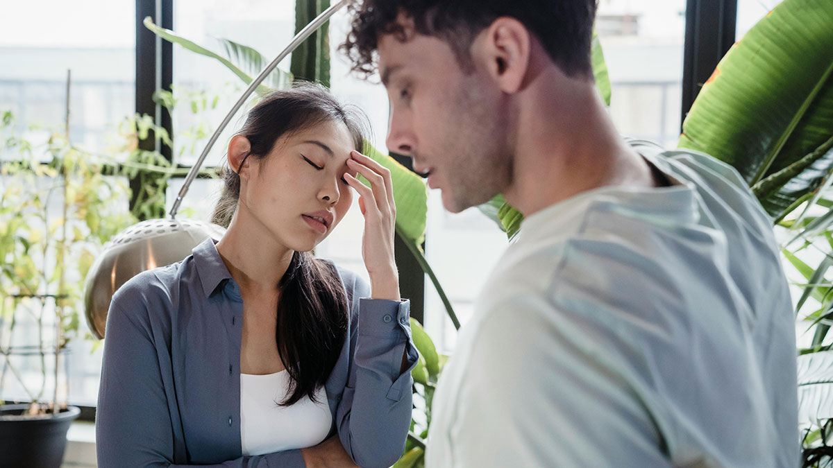 Man prepared to fight for stepson while woman looks stressed in a bright room with indoor plants in the background