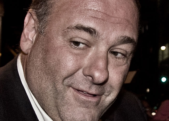 Close-up of a man smiling slightly, highlighting facial expression in a candid nighttime setting related to Rihanna slapped him facts.