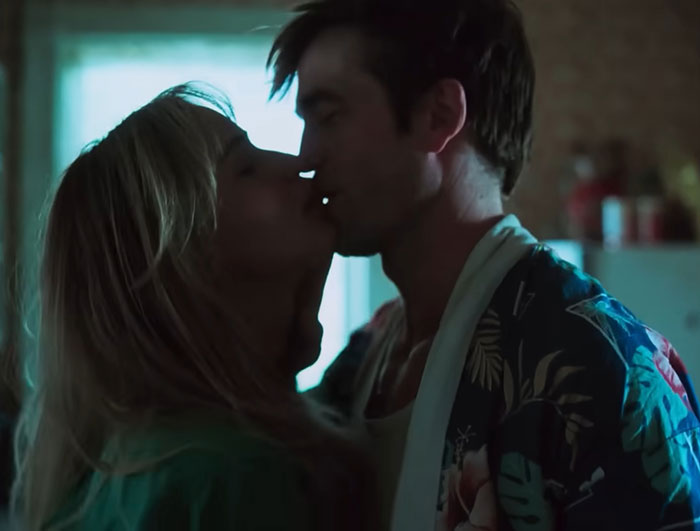 Couple sharing an intimate moment indoors, highlighting themes of art dealer connections and relationship dynamics.