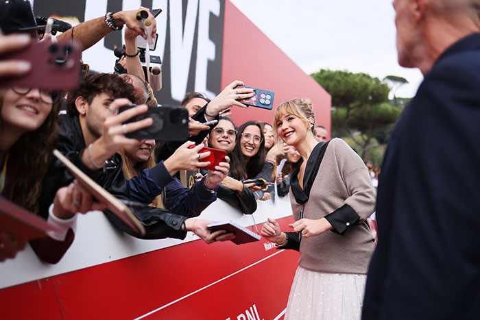 Jennifer Lawrence engaging with fans at an event, highlighting her celebrity status in the art dealer scene. Jennifer Lawrence engaging with fans at an event, highlighting her celebrity status in the art dealer scene.