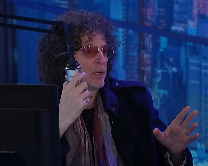 Man with curly hair and sunglasses speaking into a microphone during an online podcast about Jennifer Lopez cheating accusations. Man with curly hair and sunglasses speaking into a microphone during an online podcast about Jennifer Lopez cheating accusations.