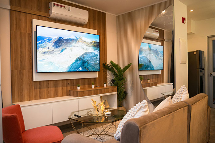 Modern living room with a large TV, brown sofa, red chair, and indoor plant illustrating financial favor and loan themes. Modern living room with a large TV, brown sofa, red chair, and indoor plant illustrating financial favor and loan themes.