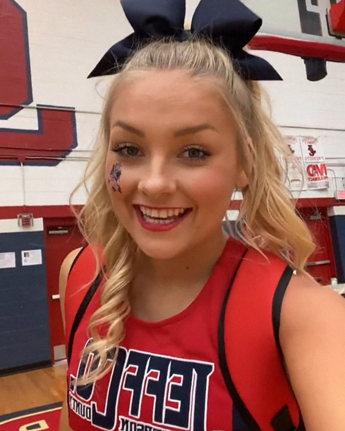 Young woman with a large bow and face paint inside a gym, related to the Laken Snelling baby case controversy. Young woman with a large bow and face paint inside a gym, related to the Laken Snelling baby case controversy.