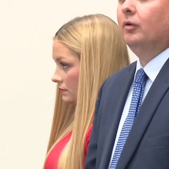 Woman with long blonde hair in red dress standing beside man in suit during legal proceedings related to Laken Snelling baby case. Woman with long blonde hair in red dress standing beside man in suit during legal proceedings related to Laken Snelling baby case.