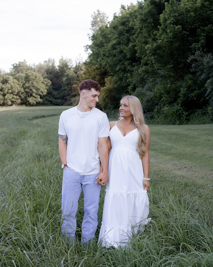 Young couple holding hands outdoors in a grassy field, related to Laken Snelling baby case public reaction. Young couple holding hands outdoors in a grassy field, related to Laken Snelling baby case public reaction.
