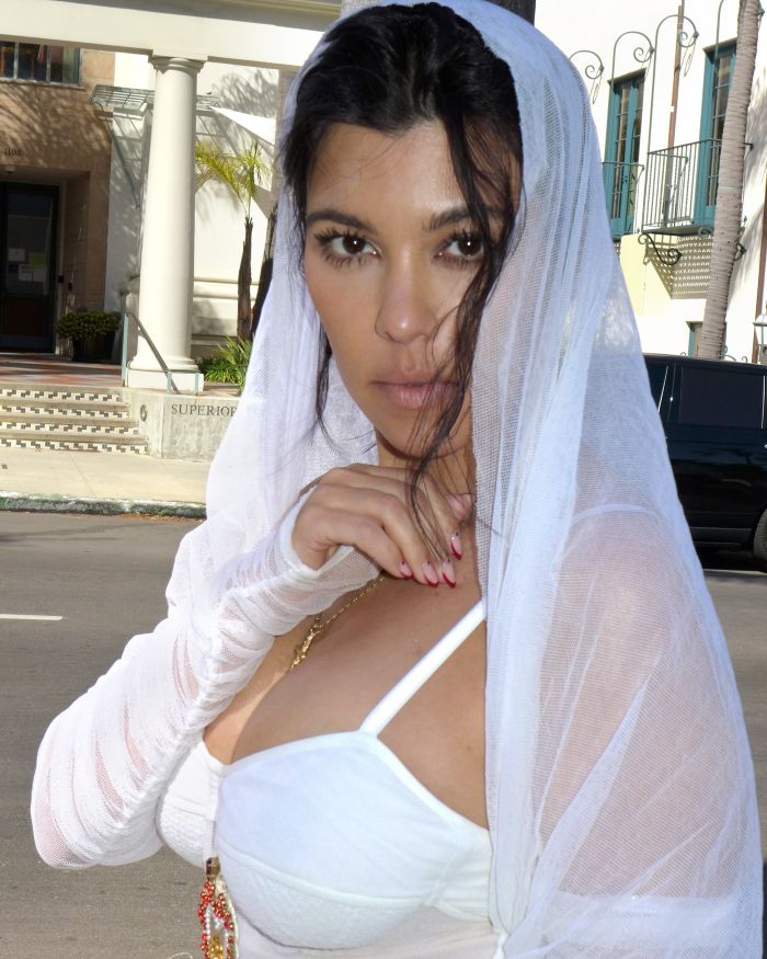 Kourtney Kardashian wearing white sheer fabric outdoors, promoting lollipops for women’s private parts with playful reactions. Kourtney Kardashian wearing white sheer fabric outdoors, promoting lollipops for women’s private parts with playful reactions.