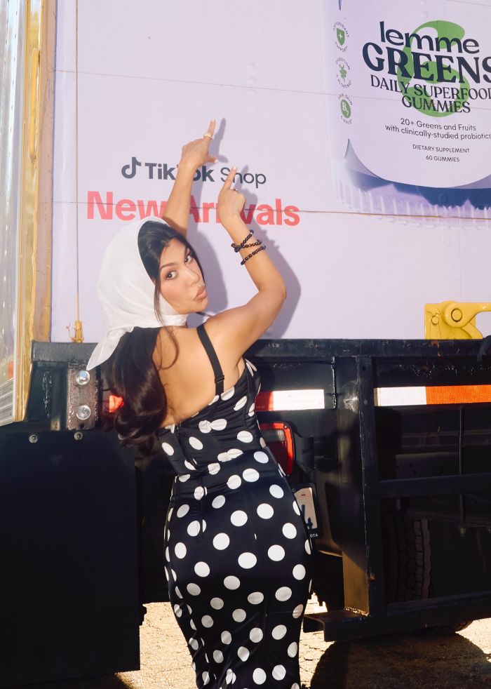Woman in polka dot dress pointing upwards, related to Kourtney Kardashian lollipops for women’s private parts launch and reactions. Woman in polka dot dress pointing upwards, related to Kourtney Kardashian lollipops for women’s private parts launch and reactions.