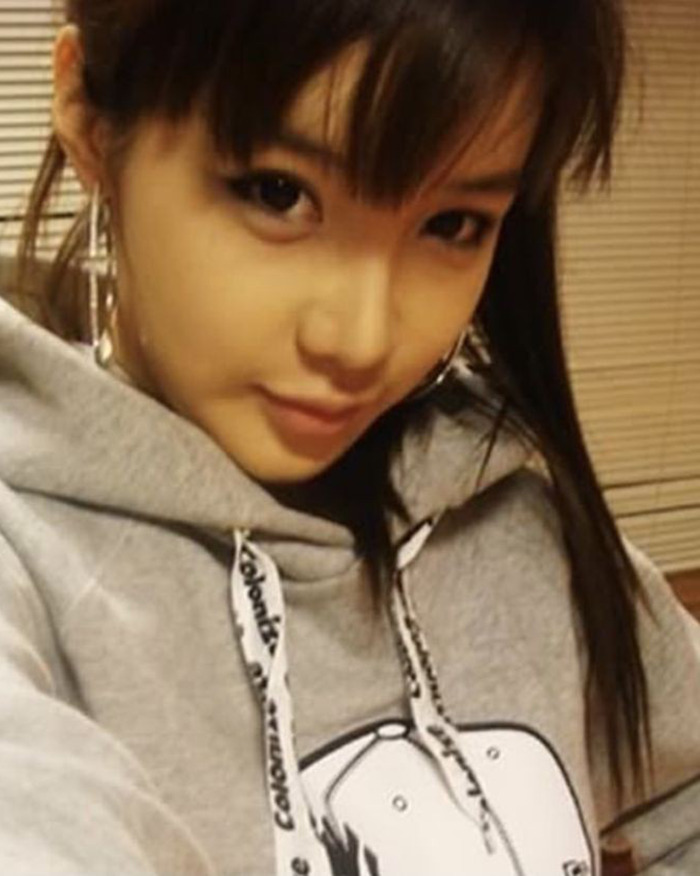 K-Pop icon Park Bom wearing a gray hoodie, showcasing her look amid her plastic surgery transformation. K-Pop icon Park Bom wearing a gray hoodie, showcasing her look amid her plastic surgery transformation.
