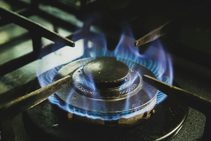 Close-up of a gas stove burner with blue flames, illustrating cooking heat for preparing shrimp jello or similar dishes. Close-up of a gas stove burner with blue flames, illustrating cooking heat for preparing shrimp jello or similar dishes.