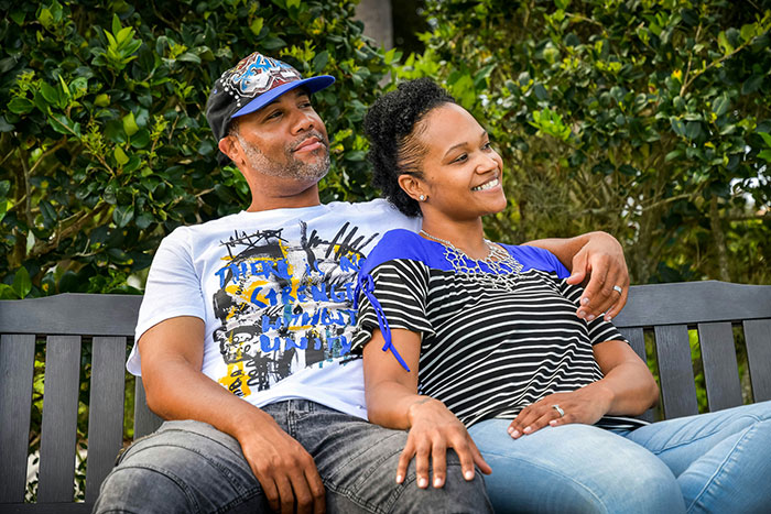 Couple sitting on bench outdoors, woman smiling while man relaxes, highlighting small financial favor and loan scenario.