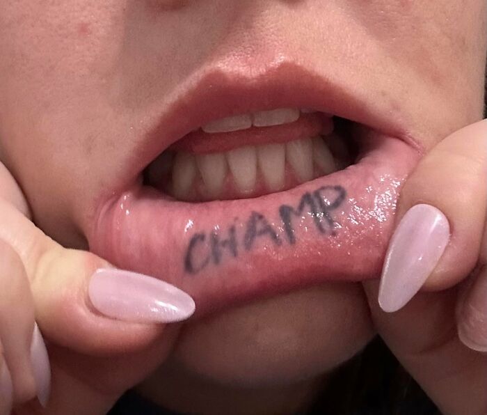 Close-up of an inner lip tattoo saying champ, highlighting a tattoo artist drawing the line on certain tattoo requests.