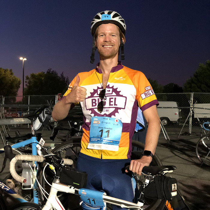 Man behind blinking guy GIF posing with bike and thumbs up, wearing cycling gear and helmet at dusk event. Man behind blinking guy GIF posing with bike and thumbs up, wearing cycling gear and helmet at dusk event.