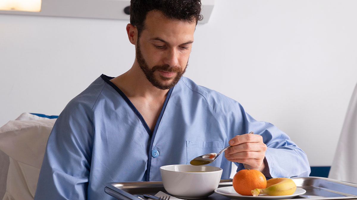 Young man in hospital gown eating soup, reflecting themes of parents begging son to care for disabled brother.