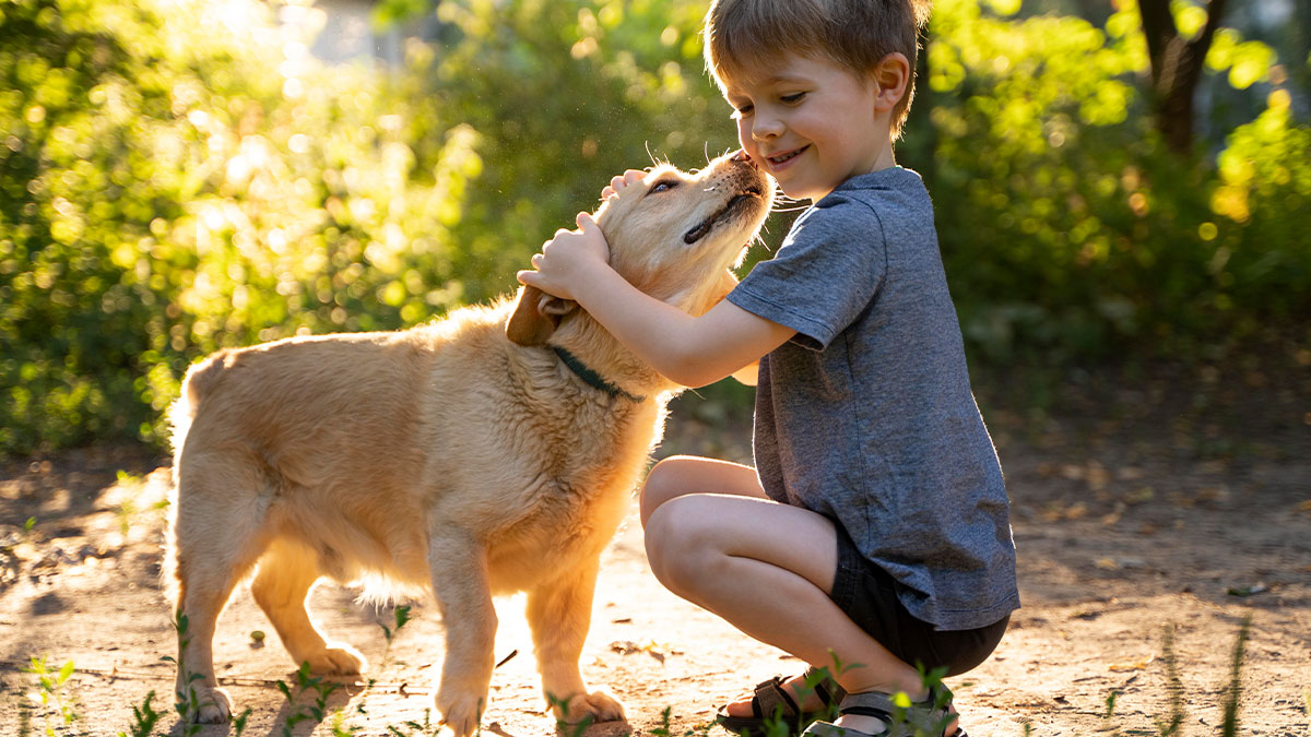 Young boy cuddling a puppy outdoors, highlighting a high-earning wife and husband puppy care conflict.