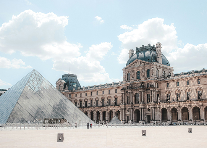 Louvre Museum exterior with glass pyramid entrance under blue sky, referencing notorious jewel thief and smuggling trick. Louvre Museum exterior with glass pyramid entrance under blue sky, referencing notorious jewel thief and smuggling trick.