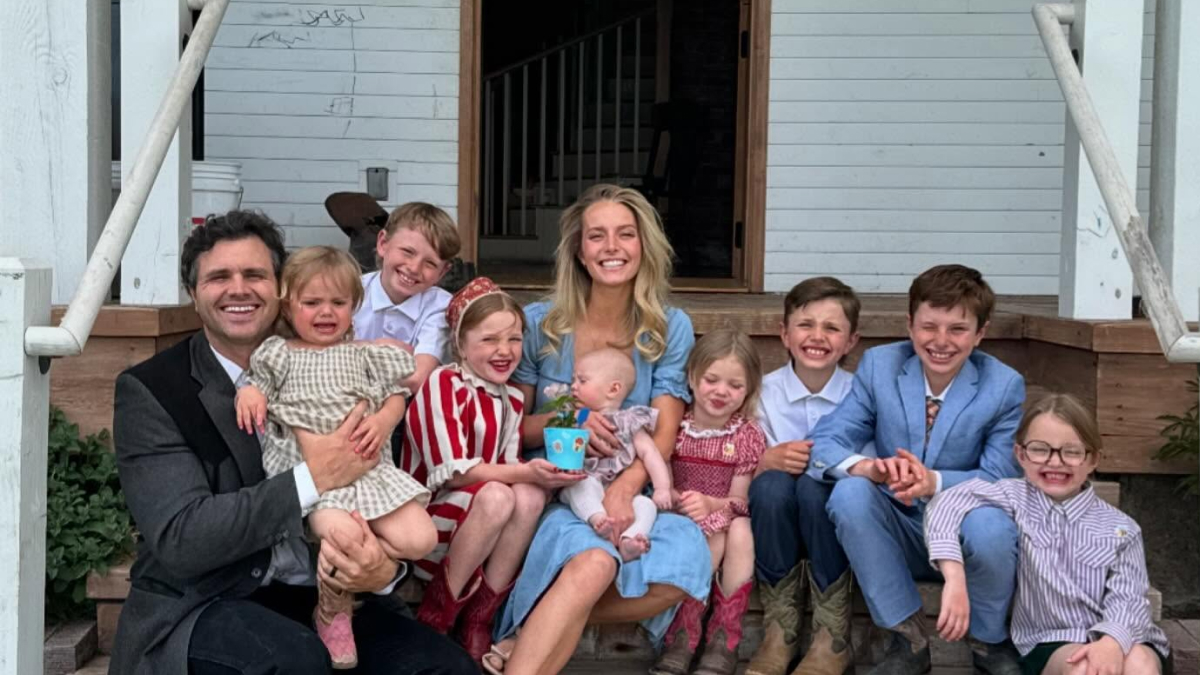 Family portrait of a trad wife with children and husband on porch highlighting the trad wife movement debate online.
