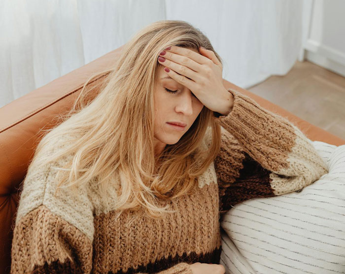Woman wearing a brown knitted sweater looking stressed, illustrating MIL trying to be the center of attention during wedding. Woman wearing a brown knitted sweater looking stressed, illustrating MIL trying to be the center of attention during wedding.