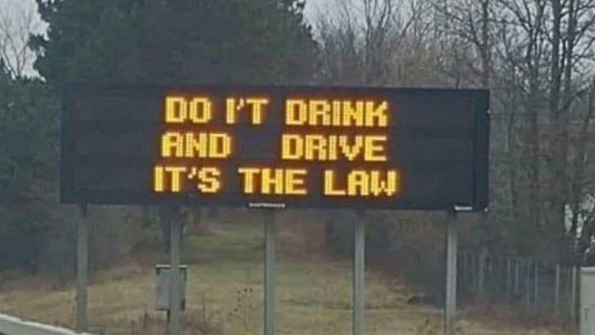LED lights on a roadside sign displaying a misled warning about drinking and driving with incorrect wording.