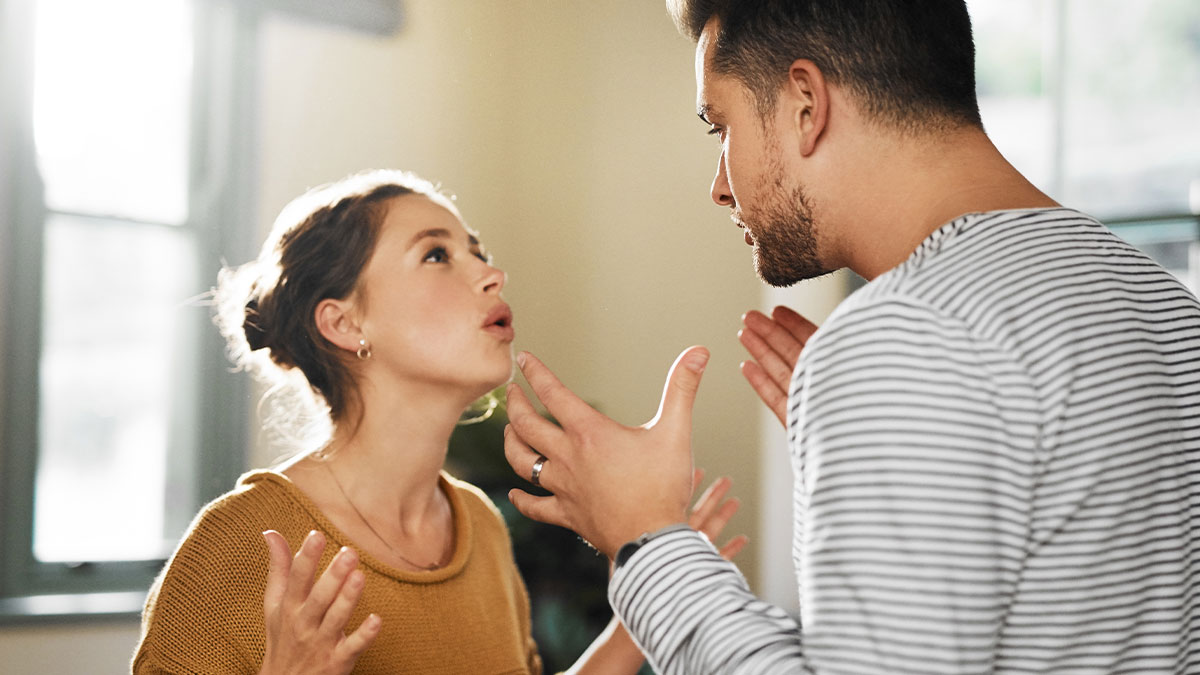 Couple in intense argument indoors, illustrating tension after mom's attempt to reconcile guy and his ex fiancu00e9.