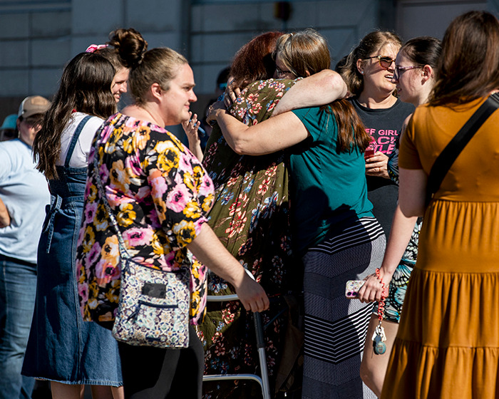 Group of people hugging and talking outside a building after a Michigan church attack involving Mormons raising funds. Group of people hugging and talking outside a building after a Michigan church attack involving Mormons raising funds.