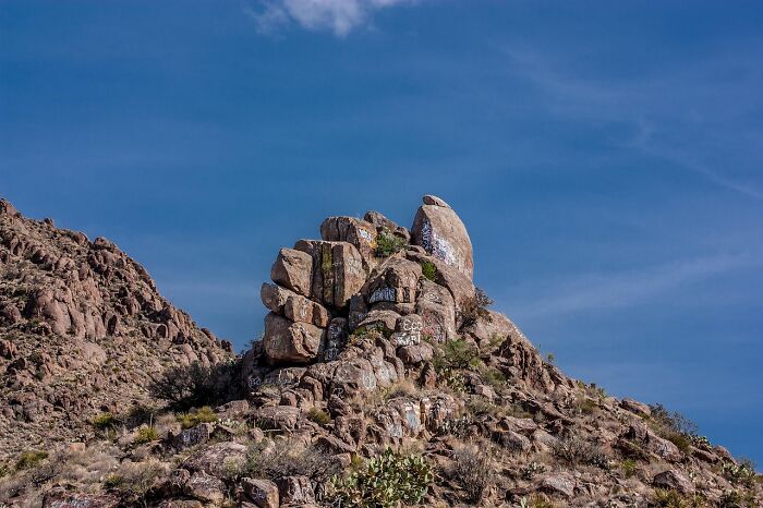 Rock formation under a clear blue sky, showcasing natural elements and incredible weather records on rugged terrain.