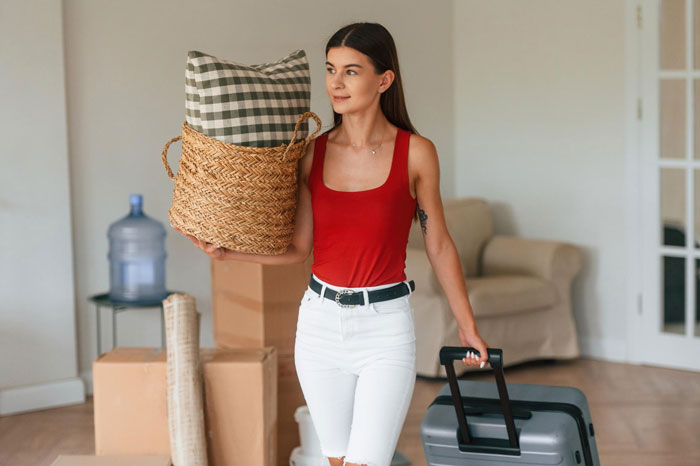 Young woman holding belongings and suitcase, depicting financial and emotional exploitation by manipulative parents.