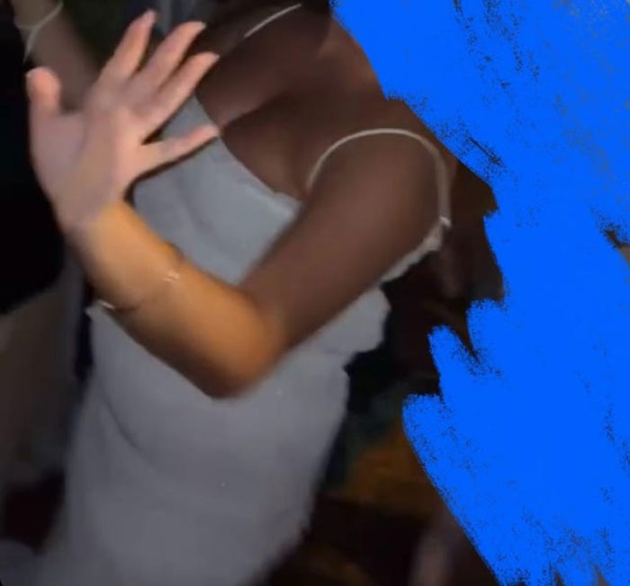 Woman in a long white dress raising her hand, captured at a wedding, highlighting bride horrified by cousin's attire. Woman in a long white dress raising her hand, captured at a wedding, highlighting bride horrified by cousin's attire.