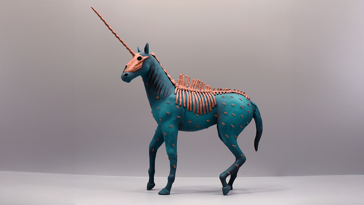 Porcelain sculpture of a unicorn with skeletal features and myth-inspired design in blue and copper tones on neutral background.