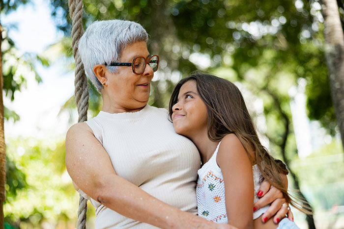 Older woman and young girl sharing a tender moment outdoors, illustrating toxic in-laws banned from visiting their newborn. Older woman and young girl sharing a tender moment outdoors, illustrating toxic in-laws banned from visiting their newborn.