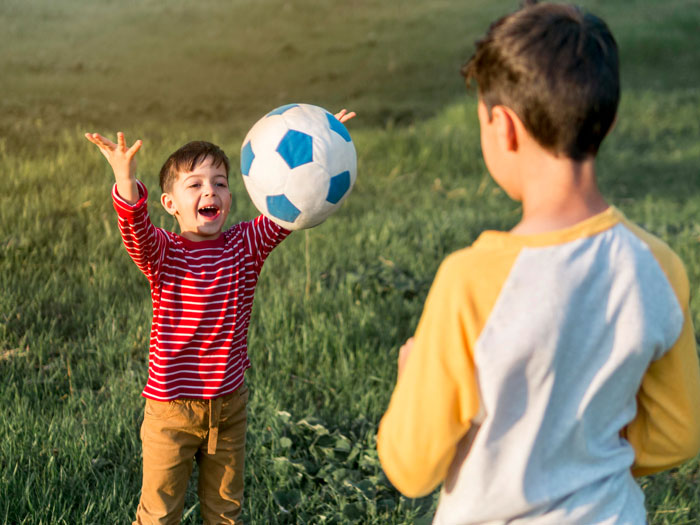 Two children playing with a soccer ball outside, illustrating neighbor kids peeking through windows on privacy issues. Two children playing with a soccer ball outside, illustrating neighbor kids peeking through windows on privacy issues.
