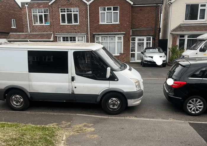 White van parked blocking neighbor's driveway on residential street, illustrating issue with male Karen behavior seen by netizens.