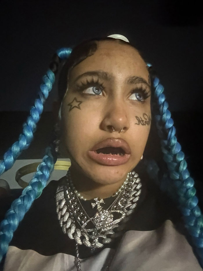 Young woman with blue braided hair and face tattoos, highlighting concerns about North's online life and new alarming look. Young woman with blue braided hair and face tattoos, highlighting concerns about North's online life and new alarming look.