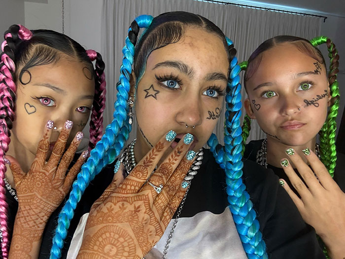 Three young women with colorful braided hair and face tattoos, highlighting Kanye West’s warning about North’s online life. Three young women with colorful braided hair and face tattoos, highlighting Kanye West’s warning about North’s online life.