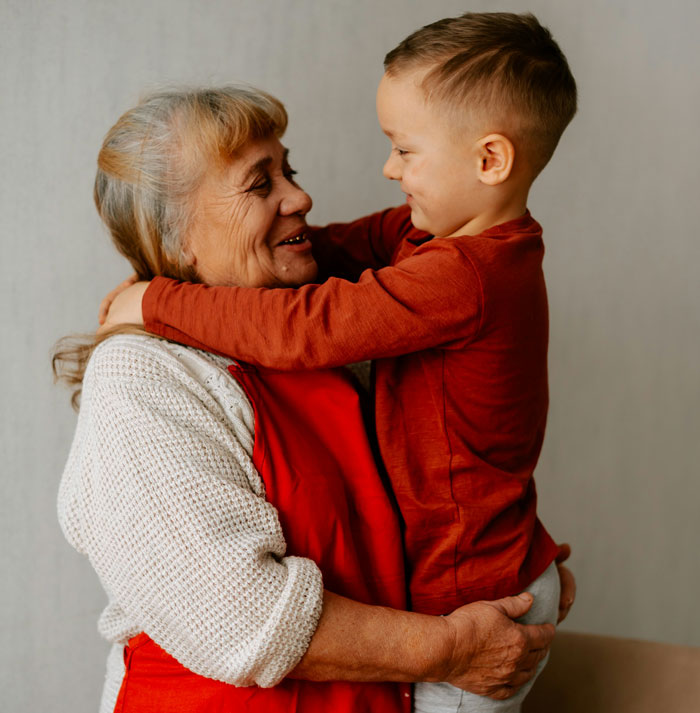 Elderly woman and young boy embracing closely, reflecting family ties and ancestry connections in a warm setting Elderly woman and young boy embracing closely, reflecting family ties and ancestry connections in a warm setting