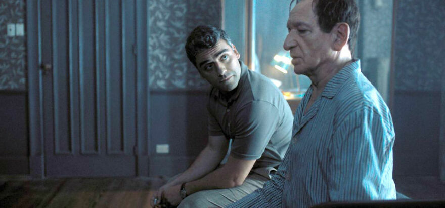 Two men seated indoors in a dramatic scene from movies based on true stories that feel impossible to believe.